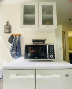 a microwave on a white counter in a kitchen at Morning Glory, Huisje vogelzang in Beekbergen +19 photos