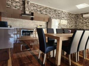 a dining room with a wooden table and black chairs at Man Cave in Dartmouth