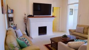a living room with a fireplace with a flat screen tv at Spacious 2BR Beachfront Apartment - The Coachhouse in Narrabeen