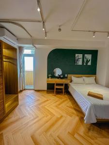 a bedroom with a bed and a green wall at International Plaza, District 1 in Ho Chi Minh City