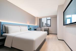 Rúm í herbergi á Atour Light Hotel Wuhan Wanxiang City Xinhua Road