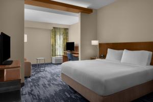 una camera d'albergo con un letto e una televisione di Fairfield Inn & Suites by Marriott Savannah Downtown Historic District a Savannah Altre 29 foto