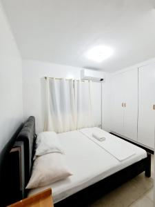 a bedroom with a bed with a white curtain at Calapan Transient Maple L82 in Calapan