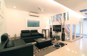 uma sala de estar com um sofá preto e uma televisão em Rainbow Residency em Nova Deli