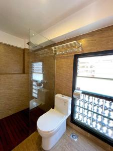 Un baño con inodoro y ducha de cristal. en Chiba Homes, en Pātan