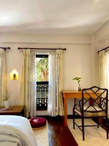 Un dormitorio con una cama y un escritorio y una ventana. en Chiba Homes, en Pātan