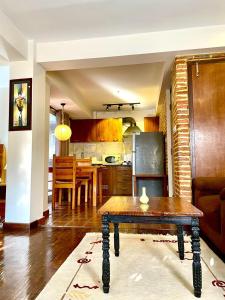 Una sala de estar con una mesa y una cocina. en Chiba Homes, en Pātan