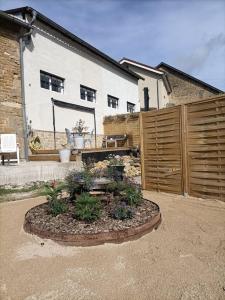 a garden in front of a house with a fence at La grange gite 2 chambres, 4 couchages in Neuilly-lʼÉvêque