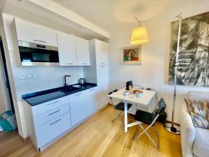 a kitchen with a sink and a table in a room at Comfortable 1-Bedroom Apartment Near Monaco in Roquebrune-Cap-Martin +13 photos