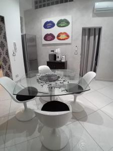 a dining room with a glass table and chairs at Casa vacanze Emma Siracusa Canicattini Bagni in Canicattini Bagni +4 photos