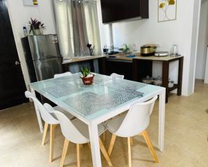 a kitchen with a glass table and white chairs at Panglao Exclusive Home in Dao +3 photos