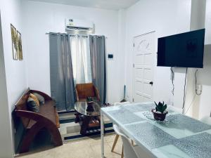 a living room with a table and a tv at Panglao Exclusive Home in Dao