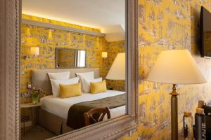 a bedroom with a mirror and a bed at H&ocirc;tel Le Relais des Halles in Paris
