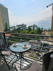 a table on a balcony with a view of a city at Gonio Apartment Seaview in Kvariati +4 photos