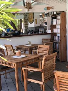 a table and chairs in a restaurant with a book shelf at Le Jardin des Portes in Les Portes