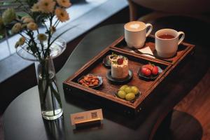 a tray with cups of coffee and fruit on a table at Yijian Hotel Wuyi Square Chaozong Street in Changsha