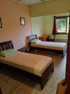 a hotel room with two beds and a window at Omanye Lodge in Accra