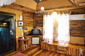 una camera con televisore e finestra con un cartello di Sangjun On Beach Resort a Bang Saphan