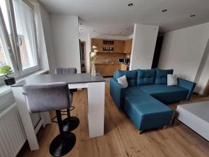 un salon avec une table et un canapé bleu dans l'établissement Ubytovanie pod Hradovou v Tisovci, à Tisovec