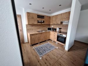 a kitchen with wooden cabinets and a sink at Ubytovanie pod Hradovou v Tisovci in Tisovec +7 photos