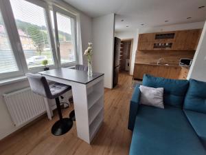 a living room with a table and a blue couch at Farmársky apartmán Agrofarma Dianiška in Tisovec