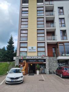 a white car parked in front of a building at Apartmán Crocus 415 in Štrbské Pleso