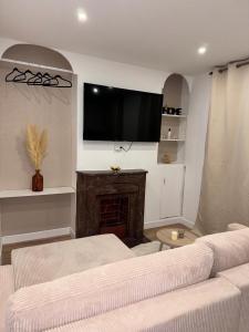 un soggiorno con camino e TV a schermo piatto di Superbes logements - Proche Stade de France et village olympique a Saint-Denis