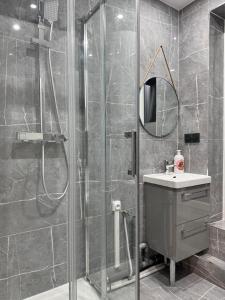 un bagno con doccia, lavandino e specchio di Superbes logements - Proche Stade de France et village olympique a Saint-Denis