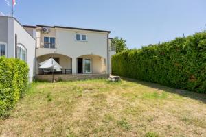 a view of the backyard of a house with a hedge at Apartments Galeb in Poreč