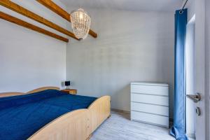 a bedroom with a bed with a blue bedspread at Apartments Galeb in Poreč