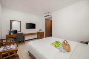 a hotel room with a bed and a chair and a television at Star Hotel and Spa Danang in Danang