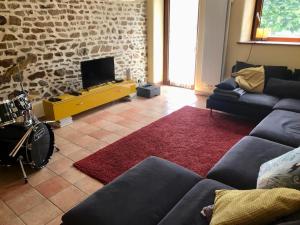 a living room with a couch and a brick wall at Longère en Bretagne in Nouvoitou