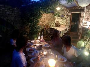 a group of people sitting at a table with food at Longère en Bretagne in Nouvoitou +21 photos