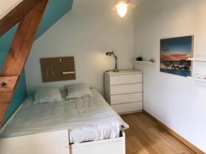 a small bedroom with a bed and a dresser at Longère en Bretagne in Nouvoitou