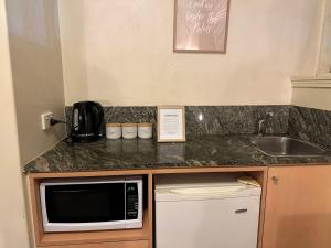 a kitchen counter with a microwave and a sink at Entire Studio Apartment in St Kilda FREE PARKING WIFI BEACH WALK in Melbourne