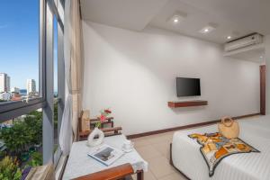 a living room with a couch and a tv at Star Hotel and Spa Danang in Danang