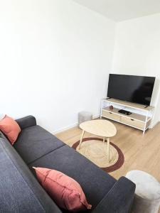 Una sala de estar con un sofá azul y una mesa. en Superbe appartement rénové, en Bourges
