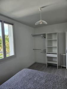 Un dormitorio blanco con una cama y una ventana. en Superbe appartement rénové, en Bourges