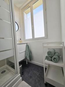 y baño con lavabo, ventana y toallas. en Superbe appartement rénové, en Bourges 13 fotos más