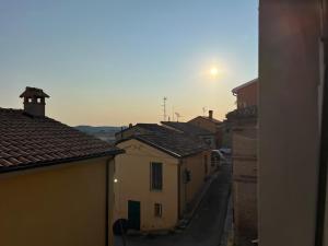 a view of a street with buildings and the sun in the sky at La casa di Pi in Montacuto