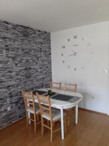 a dining room with a table and chairs and a clock at Apartman Marija, Lukavica, Istočno Sarajevo in Lukavica