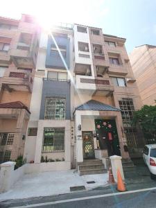 a building with the sun shining on the front of it at 花蓮後站-沐青文旅 in Hualien City