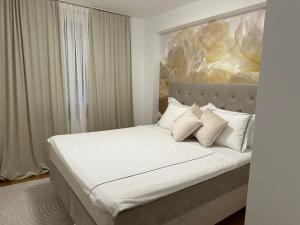 a bedroom with a large bed with white sheets and pillows at Sky hill residence Mostar in Mostar +26 photos