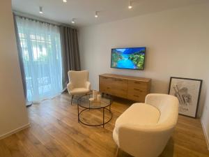 un salon avec deux chaises et une télévision dans l'établissement Luna, à Floreşti