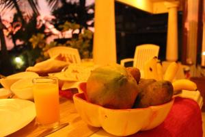 a bowl of fruit on a table with orange juice at Janishi Residencies in Negombo