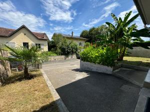 ヴィルヌーヴ・シュル・ロットにあるVilla des palmiersの前に植物が植えられた私道のある家