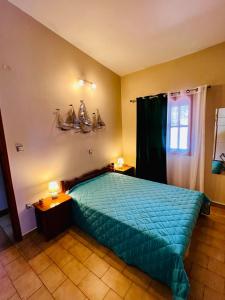 ein Schlafzimmer mit einem Bett mit einer blauen Bettdecke in der Unterkunft Ioanna's sweet & cozy apartment with sea view in Monemvasia