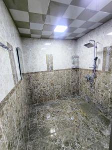 a tiled bathroom with a shower and a sink at Green Home in Gabala +12 photos