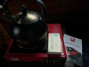a tea pot sitting on top of a red box at Eco Crofter's Wagon by the Sea - Off Grid Experience - No electricity - As seen soon on Netflix in Oldshoremore