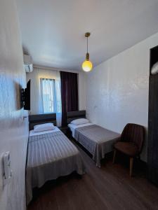 a hotel room with two beds and a chair at Villa Harmony in Chakvi +47 photos